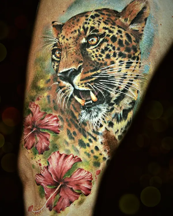 Jaguar with hibiscus flowers tattoo by Damián Calandra