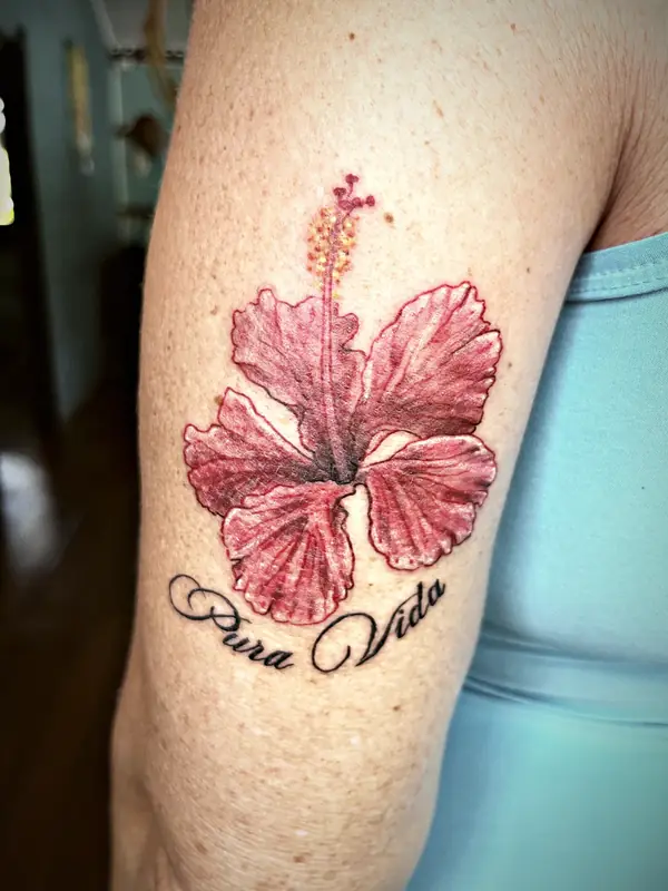 Hibiscus with Pura Vida script tattoo by Damián Calandra